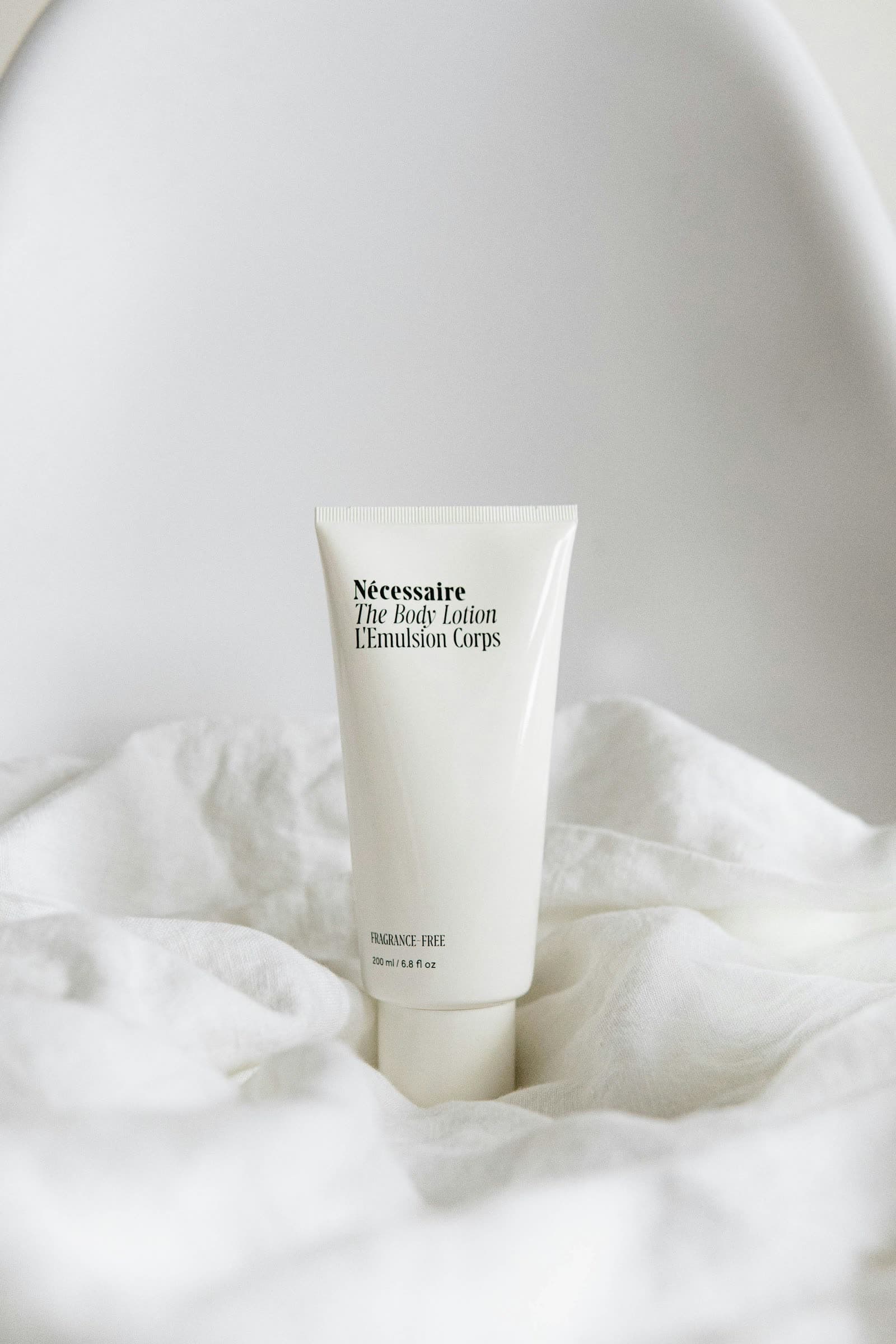 Skincare lotion tube on white linen